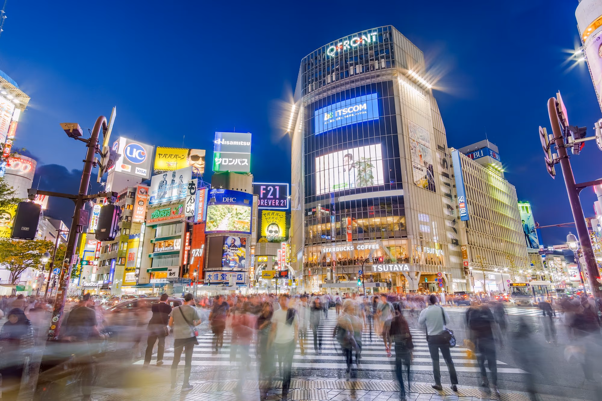 Fußgänger füllen bei Grün die Shibuya-Kreuzung